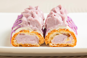 Golden baked choux pastry filled with Ube pastry cream and decorated with colored white chocolate.
