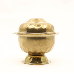 a golden container pot with vintage design and a lid for the box used to store food spice or sindoor powder isolated in a white background