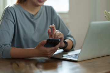 Happy young asian female accountant Positive concept using smartphone at her desk to relax with mobile application and use to chat business contact online marketing Excellent profit.