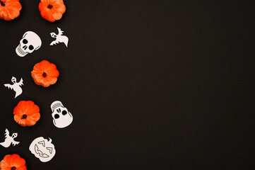 Layout of Halloween decorations on a black background:pumpkins,skulls,ghosts.Halloween concept. Flat lay.Copy space.