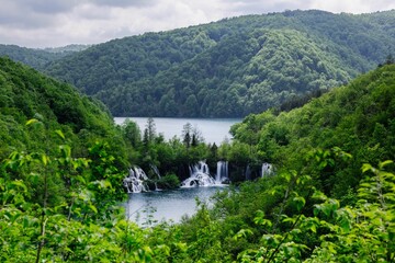 Tranquil scene of the Plitvice Lakes in Croatia with waterfalls surrounded by lush green foliage