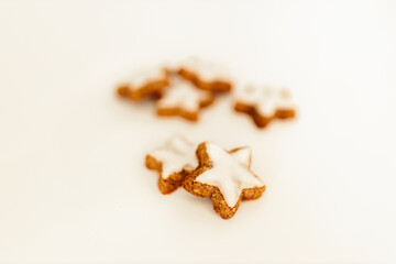 Gingerbread cookies in the shape of stars on a white table against a background of bokeh of New Year's golden lights. Christmas background. Winter card. Delicious pastries close-up