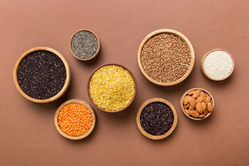 Various superfoods in smal bowl on colored background. Superfood as rice, chia, quinoa, lentils,...
