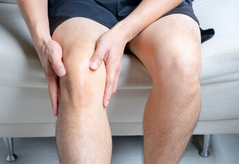 Man with knee pain, he puts his hand on his knee, pain point from osteoarthritis and...