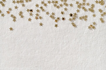 Festive party celebration background with copy space, gold star confetti border on neutral beige linen fabric texture. Winter holiday announcement, advertising design template for business brand