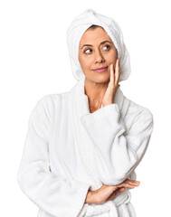 Middle-aged woman in bathrobe and towel looking at camera