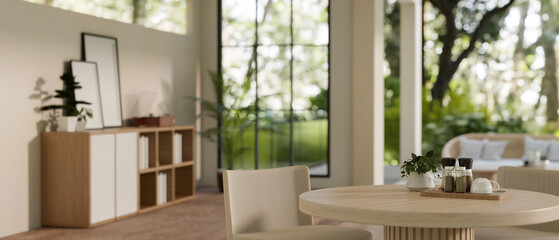 A minimal dining table with spice bottles and a potted plant in a modern Scandinavian living room.