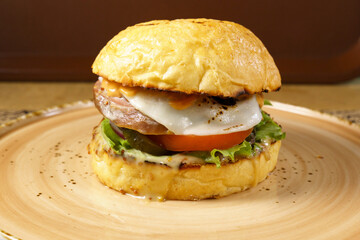 Burger with beef tongue, cheese salad and tomato close-up. Selective focus