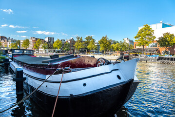 Traditional Amsterdam canal with boats houseboats and bridges