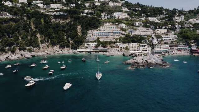 Aerial view flying towards Italy's tourist packed beaches.