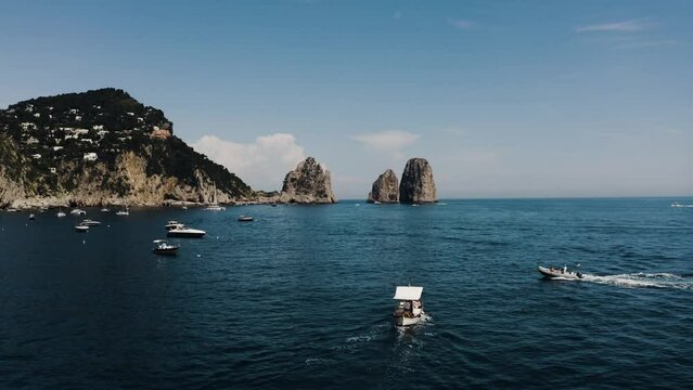 Drone shot of boats traveling along Italy's beautiful shoreline.