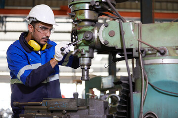 factory worker or technician checking and control lathe machine in factory