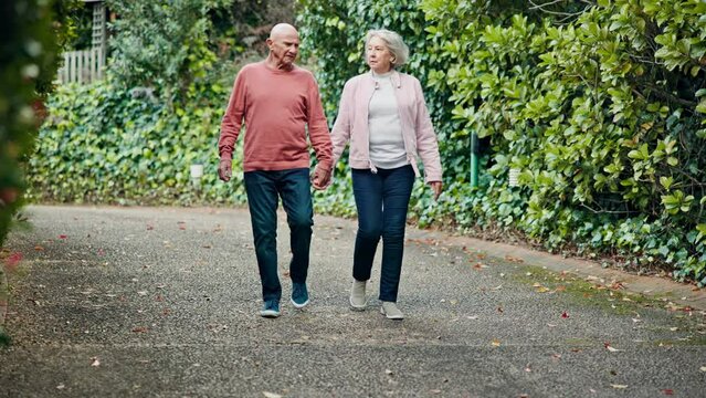 Walk, holding hands and old couple in garden with support, love and relax in retirement. Marriage, senior man and woman on park path together with nature, trees and bonding on outdoor morning chat.
