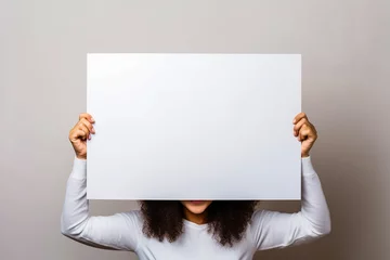 Foto op Canvas Femme tenant un panneau blanc vide pour texte ou message © Concept Photo Studio