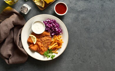 Schnitzel with potato fries, cabbage salad and sauce