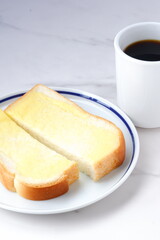 マーガリンを塗ったパンとコーヒーの朝食