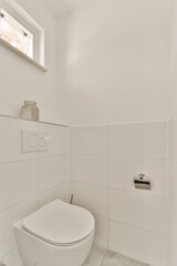 a white toilet in the corner of a bathroom with tile flooring and wall tiles on the walls there is a window