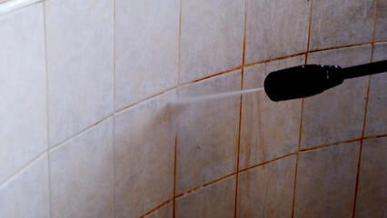 Cleaning dirty tiles with water pressure washer. Concept of a cleaning company, general cleaning,...