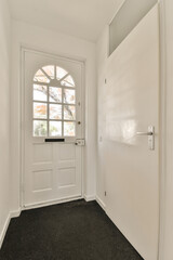 an empty room with a white door and black carpet on the floor in front of the door is a window