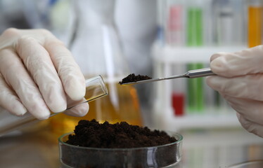 Female chemist in white protective gloves hold test tube against chemistry lab background closeup....