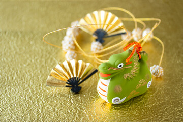日本の正月イメージ　干支　辰と金扇と手毬のガーランドのデザイン（キラキラ金色和紙の背景）
