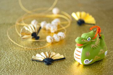 日本の正月イメージ　干支　辰と金扇と手毬のガーランドのデザイン（キラキラ金色和紙の背景）