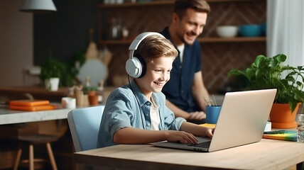 Boy in headphones is using laptop and studying online at home. - obrazy, fototapety, plakaty