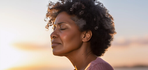 Close up lifestyle portrait of exhausted and stressed middle aged black woman standing outside with sky background - obrazy, fototapety, plakaty
