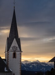 Winter sunset landscape of an old austrian church in an alps village, snowy mountains, Wallfahrtskirche Maria Schnee Matzelsdorf