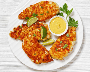 fried chicken cutlets on white plate, top view