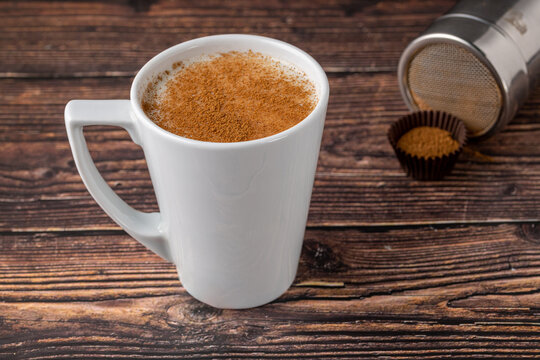 Cinnamon sprinkled salep in a white cup on wooden table