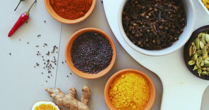 Spices, herbs and curry on table top in kitchen for cooking, food or seasoning collection with color. Top View, powder and tumeric or salt with colorful seeds, cumin and masala on arrangement board