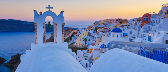 White churches an blue domes by the ocean of Oia Santorini Greece, traditional Greek village