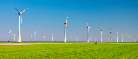 Windmill turbines with a green meadow field, huge windmill park in the Netherlands