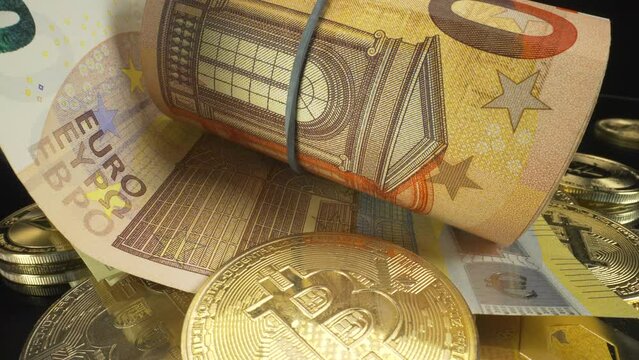 Slow turning macro view of rolled up cash, paper money euros and dollars on cryptocurrency coins with black background, 4K shot