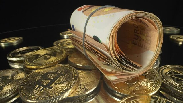 Zooming out of a slow turning macro view of rolled up cash, paper money euros on cryptocurrency coins with black background, 4K shot