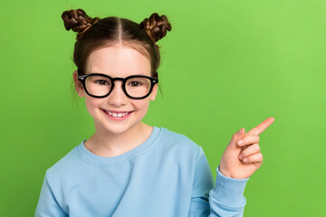 Portrait of funny small girl wear on eyesight specs eyeglasses direct finger empty space banner isolated green color background
