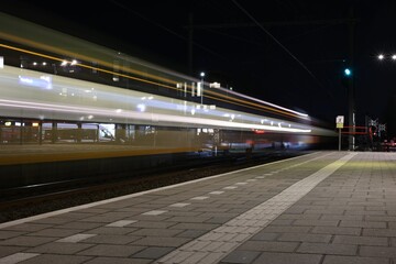 a blurry view of an empty train platform by night