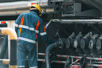 oil and gas workers fueling large fuel-truck, tanker inside refinery., Fueling Up a Freight...