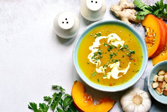 Autumn pumpkin soup with ginger and garlic. Top view with copy space.