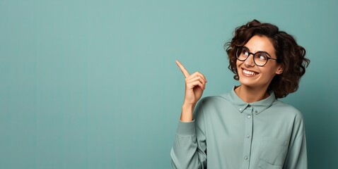 Girl with smiling glasses looking to the side and pointing her finger. Copy space with minimalist background