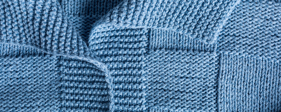 Close up view banner of handemade knitted blue women jumper with polo collar. Stylish cotton pullover with chess texture pattern and long sleeves front view. Top view