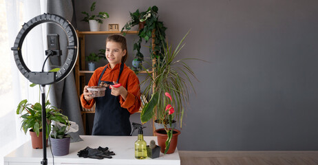 Young girl creator recording online media video on her room about transplant houseplants. Teenager...