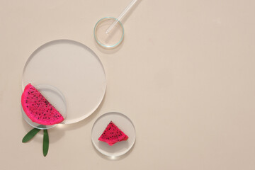 Glass props are showcased against a minimalist backdrop, accompanied by fresh dragon fruit. This serves as a mockup for cosmetic advertising featuring dragon fruit extract.