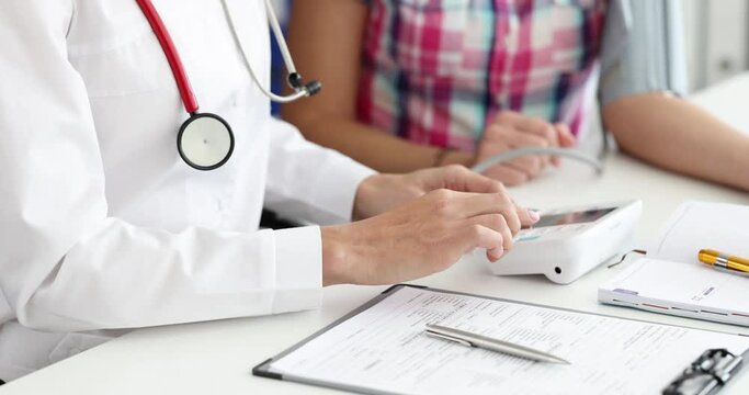 Doctor measures arterial blood pressure with tonometer of patient in clinic. Reasons for high and low pressure concept