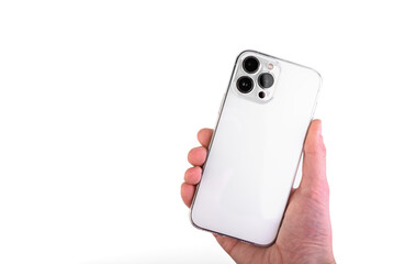 Hand holding white smartphone with silicone transparent phone case isolated on white background.