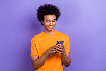 Portrait of positive attractive man use smart phone blogging empty space isolated on purple color background