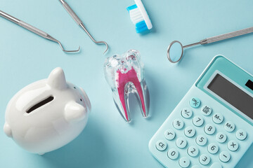 Dental tool and tooth with piggy bank and calculator on blue background