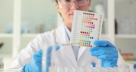 Urine pH test strips closeup. Doctor or laboratory scientist conducting a test with litmus strips