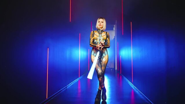 Fashion model posing Fantasy cyborg woman creative robot costume metal body creative makeup, cyberpunk style blonde hair. Sexy alien girl in virtual reality war warrior future vr laser sword in hands 